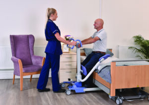 Carer using patient handling equipment to help a patient.